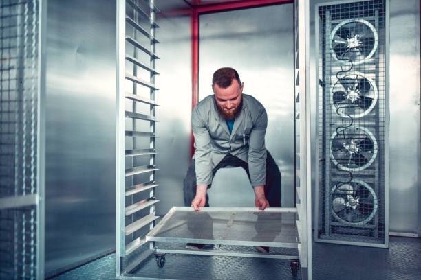 Worker Setting Up Drying Pads In Drying Chamber